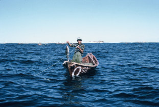 Jovem pescador exibindo um bacalhau